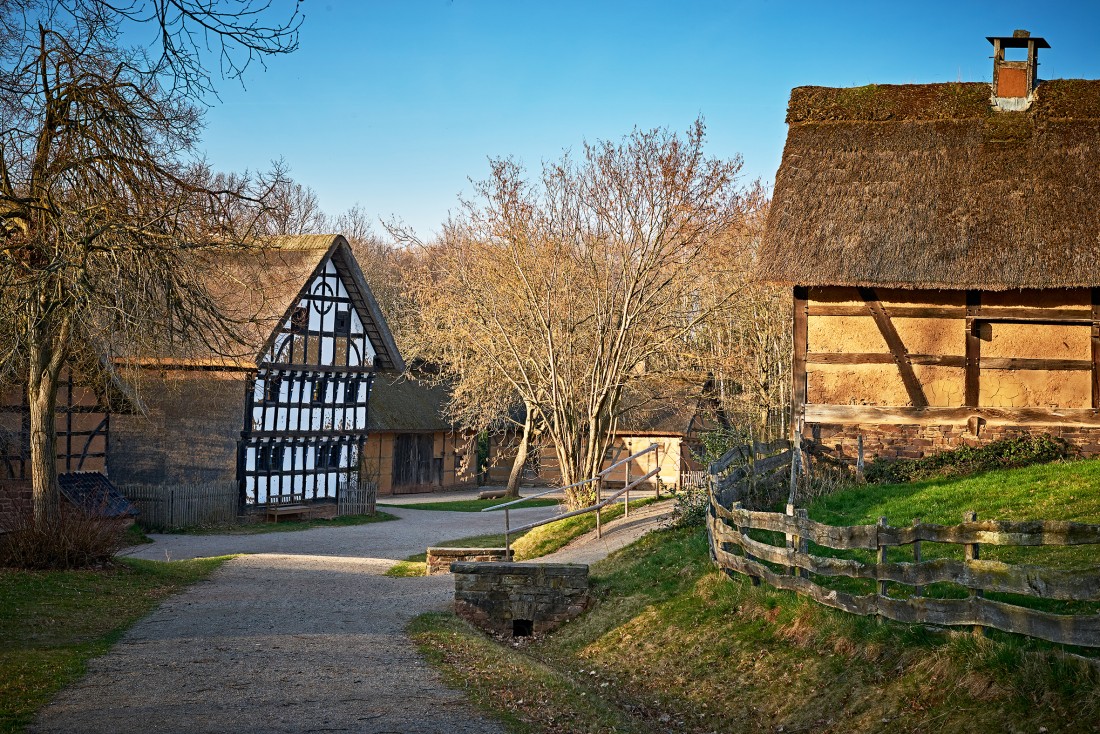 Weg in die Baugruppe Eifel, rechts steht ein Fachwerkhaus mit hellbraunen Gefachen, links eines mit weißen Gefachen
