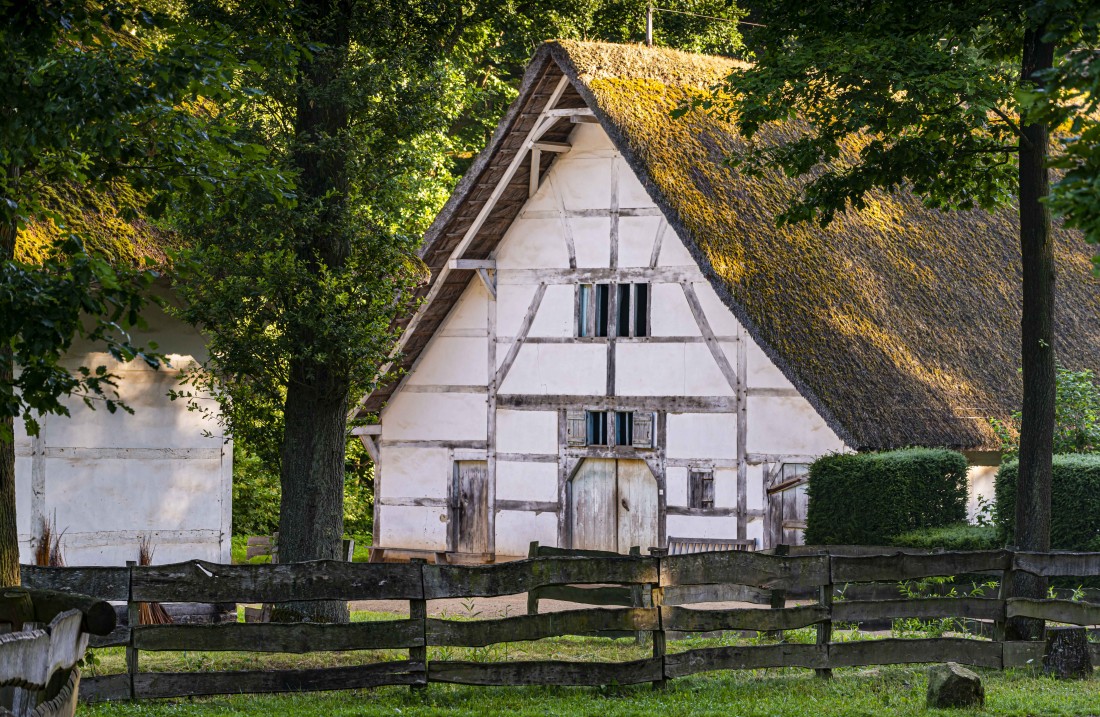 weißes Fachwerkhaus hinter einem Holzzaun