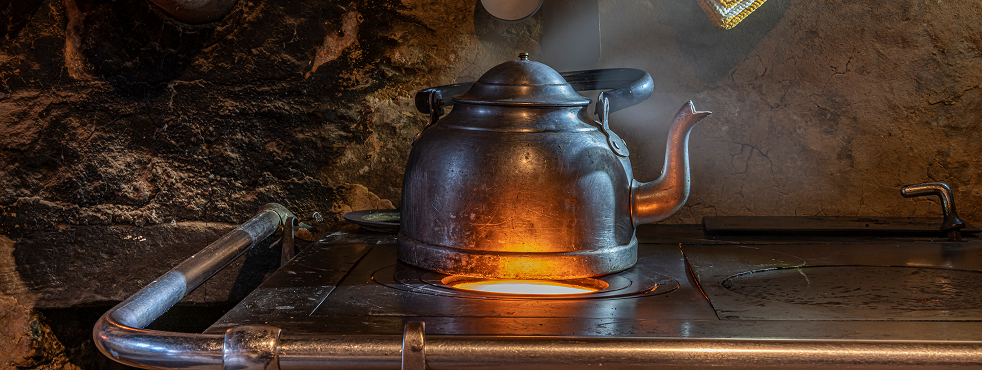 Metal tea kettle on an economy stove
