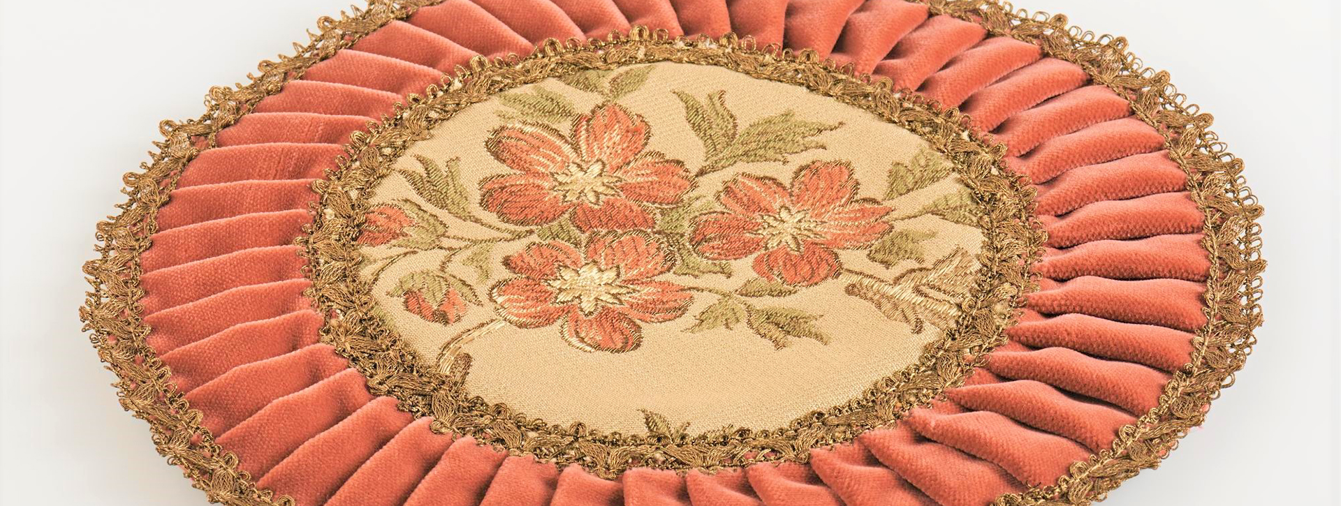 Zierdeckchen mit orangerotem Rand und Blumenmuster in der Mitte