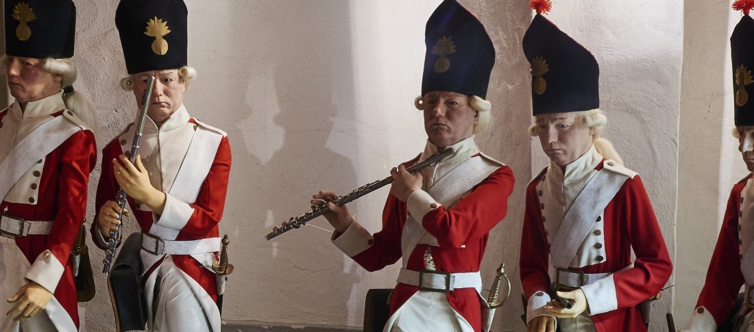 Soldiers in white and red uniforms with instruments