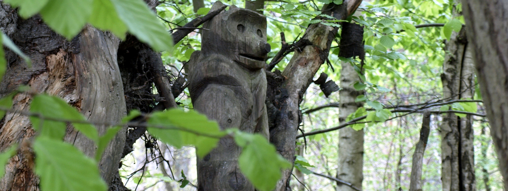 aus Holz geschnitzter Affe sitzt in einem Baum