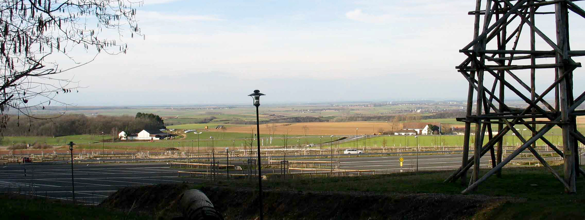 Blick über den Parkplatz auf die Felder, rechts im Bild steht der Trigonometrische Turm
