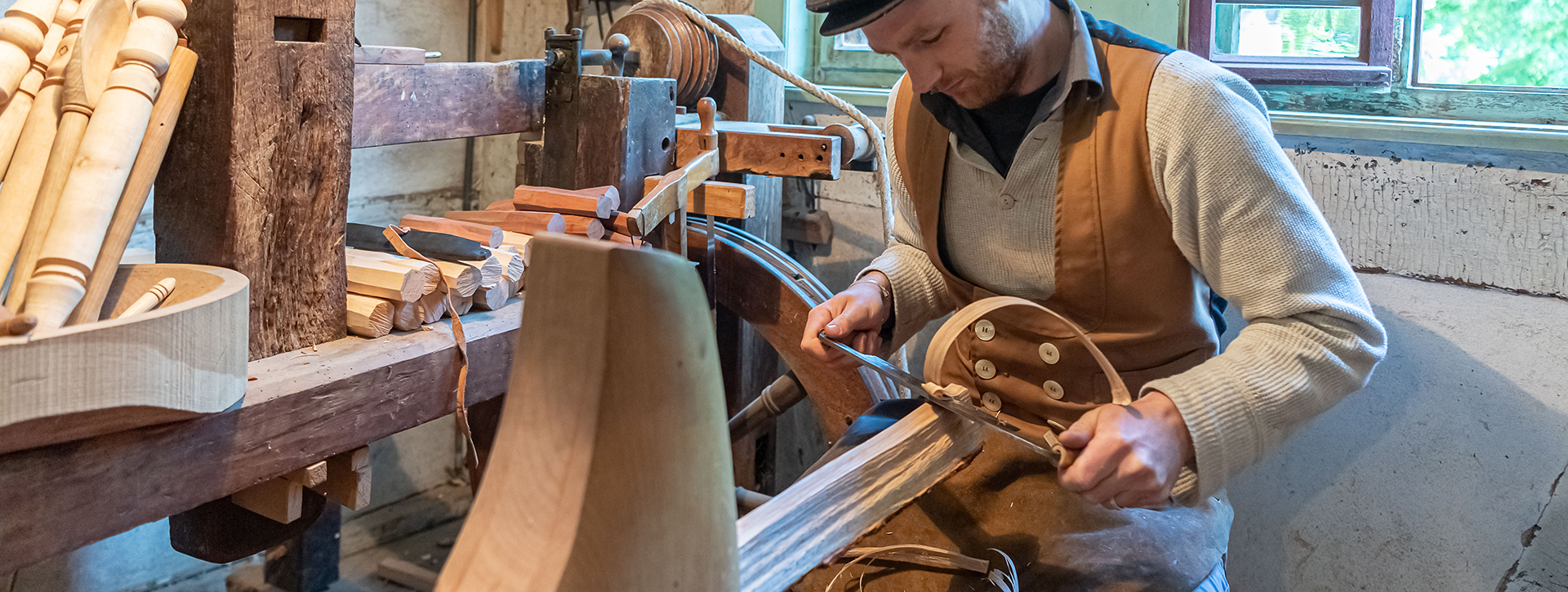 Ein Mann arbeitet mit einem Hobel an einem Holzstück