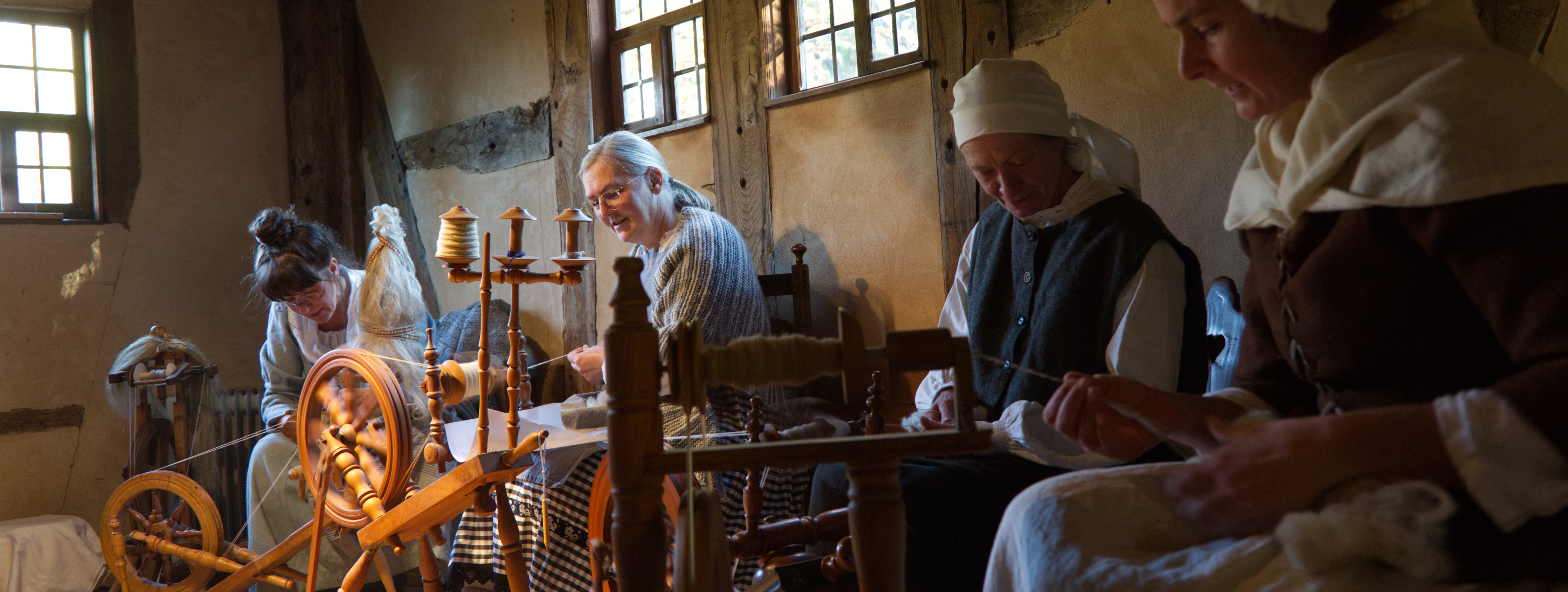 Women sitting in a room with various handicraft tools