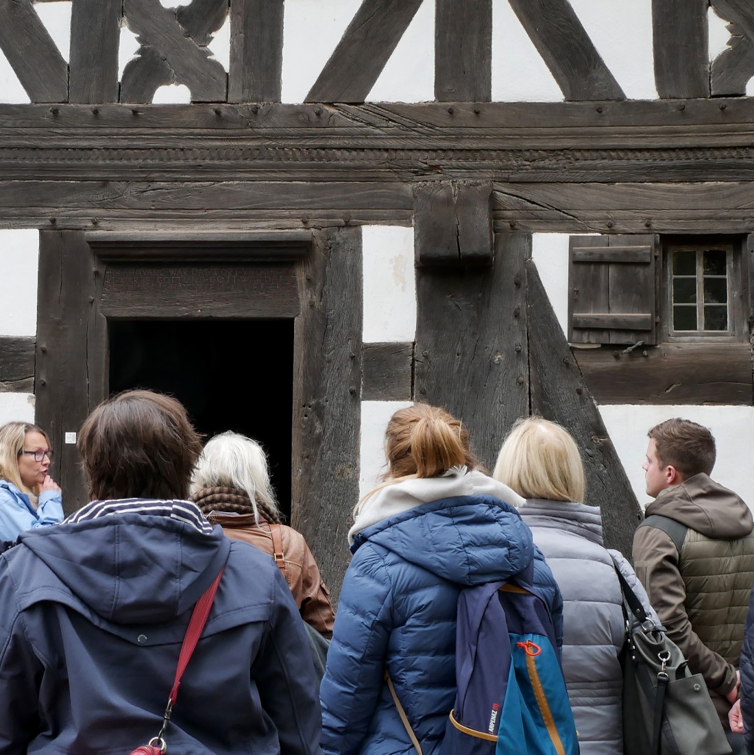 Menschen vor einem Fachwerkhaus