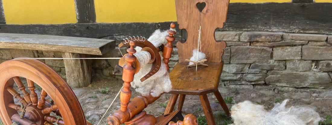 Stuhl mit Handspindel und Spinnrad