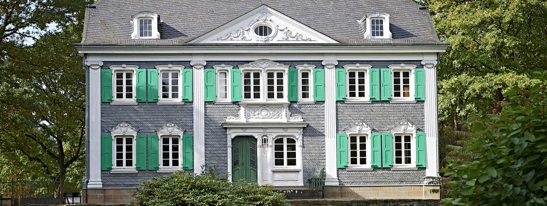 Villa mit Schieferverkleidung und gr&uuml;nen Fensterl&auml;den