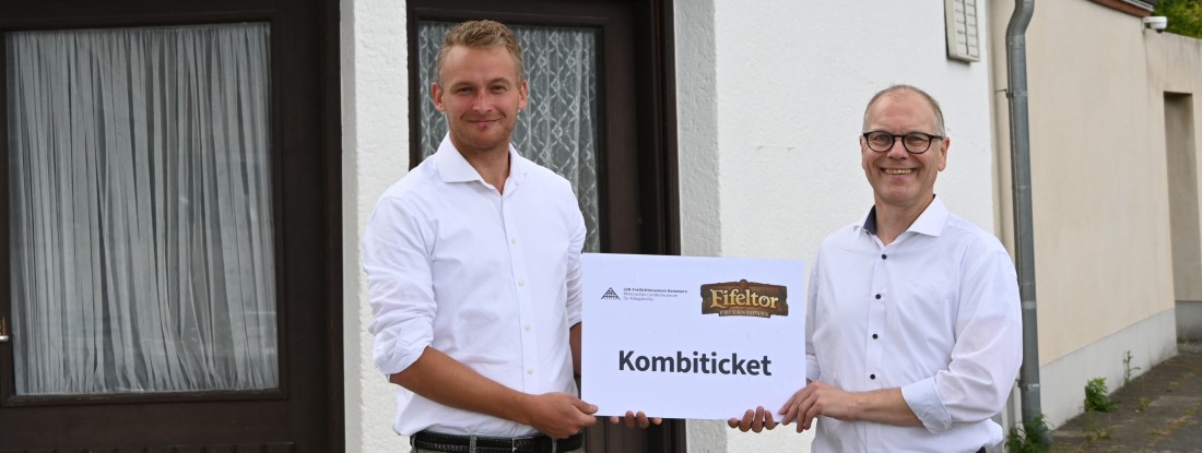 2 M&auml;nner halten ein Schild "Kombiticket"