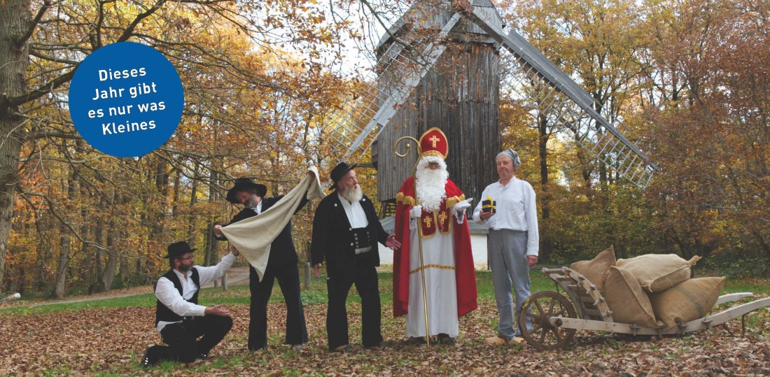 Weihnachtsmann mit anderen Personen und Esel vor einer M&uuml;hle