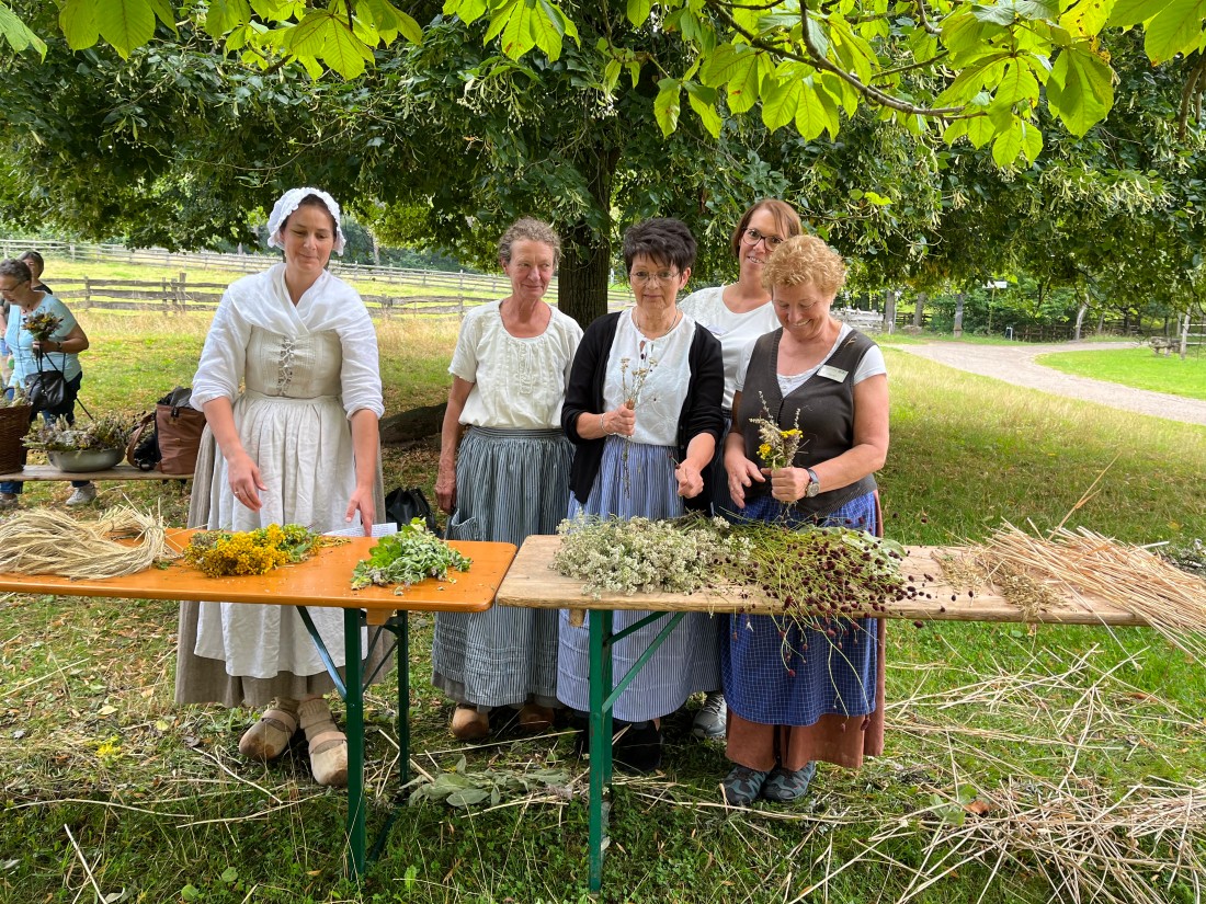 Frauen vor einem Tisch mit Kräutern