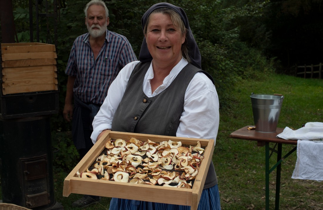 Woman shows a tray with dried apple rings