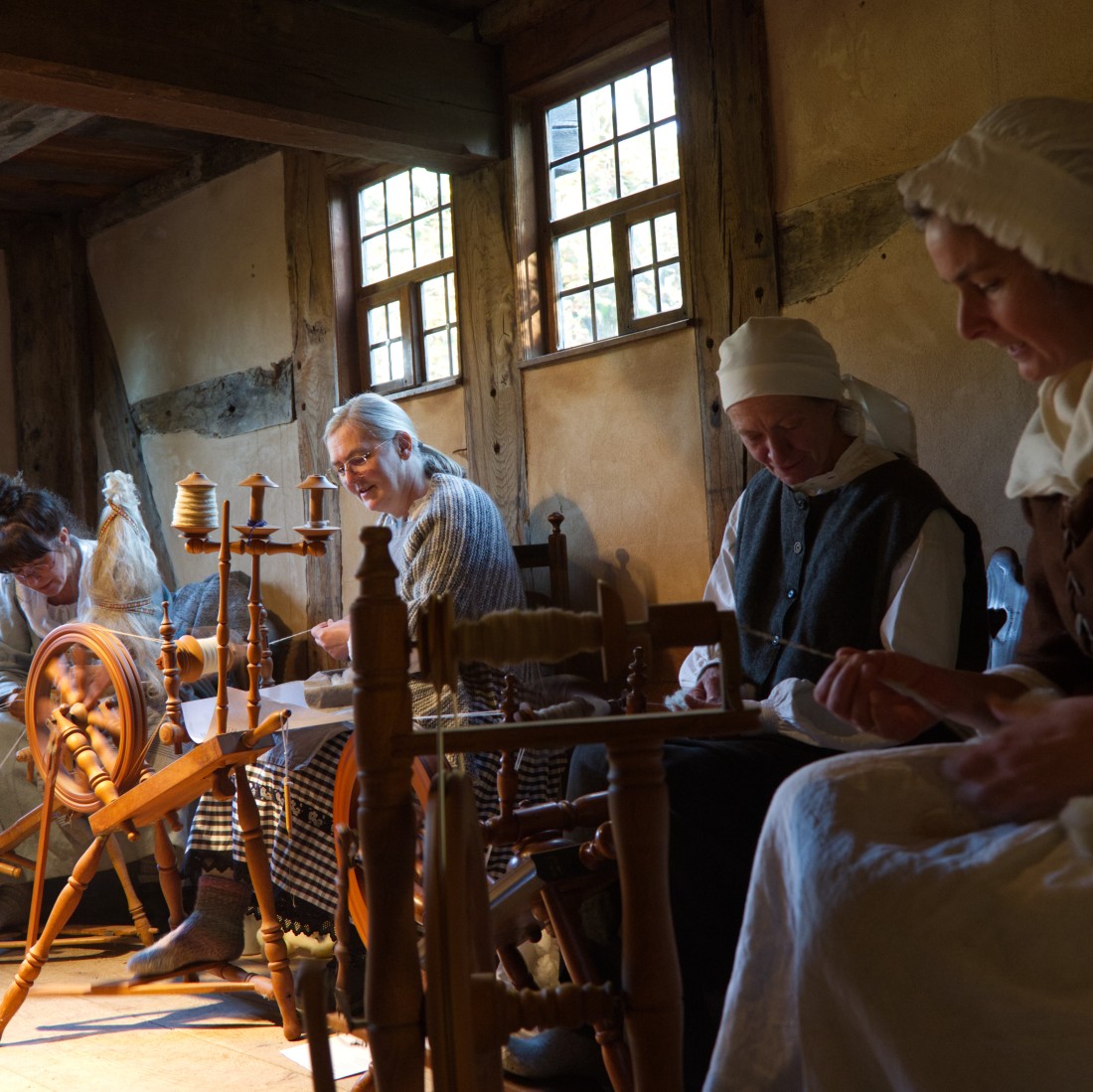 Women sitting in a room with various handicraft tools