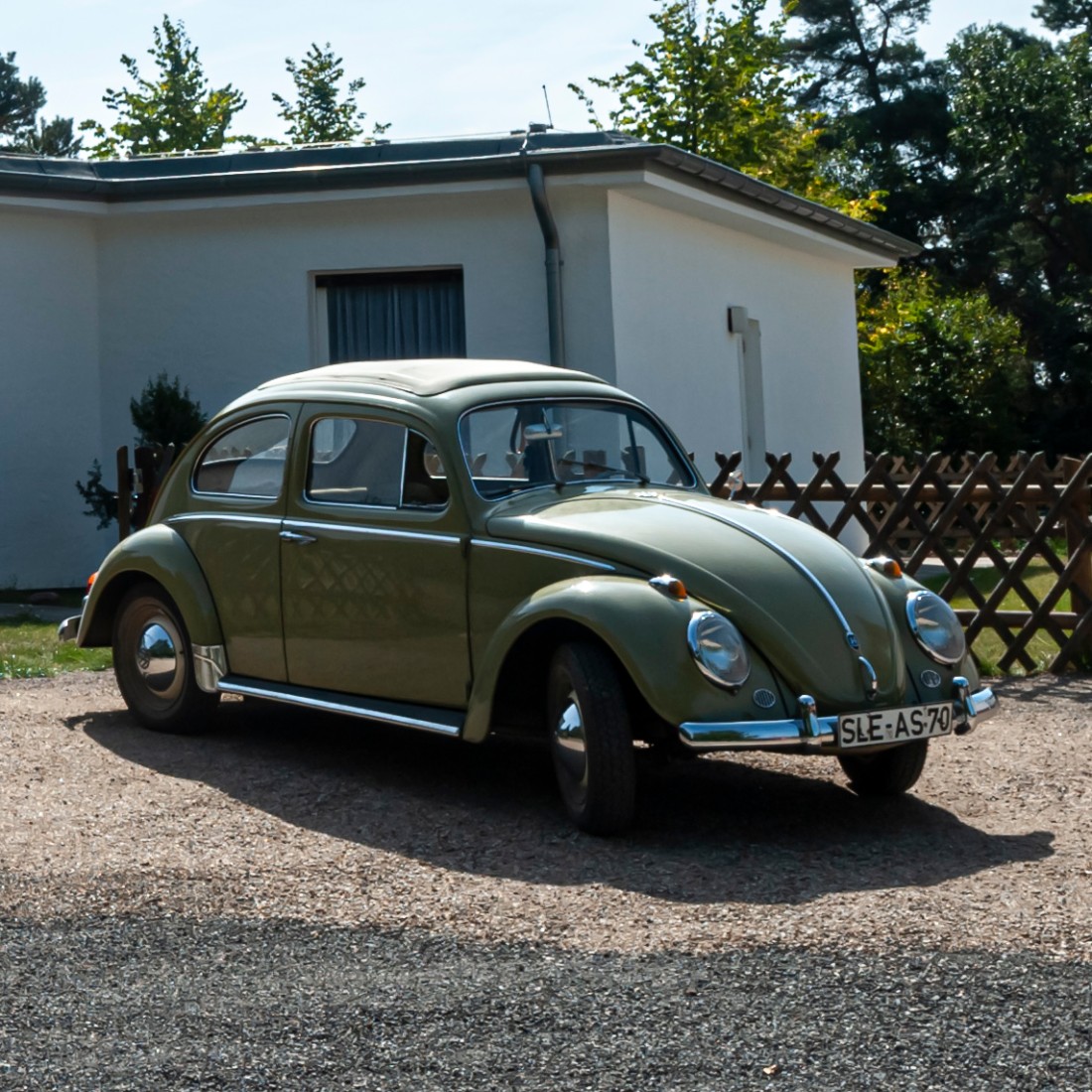 Alter VW-Käfer vor einem Bungalow