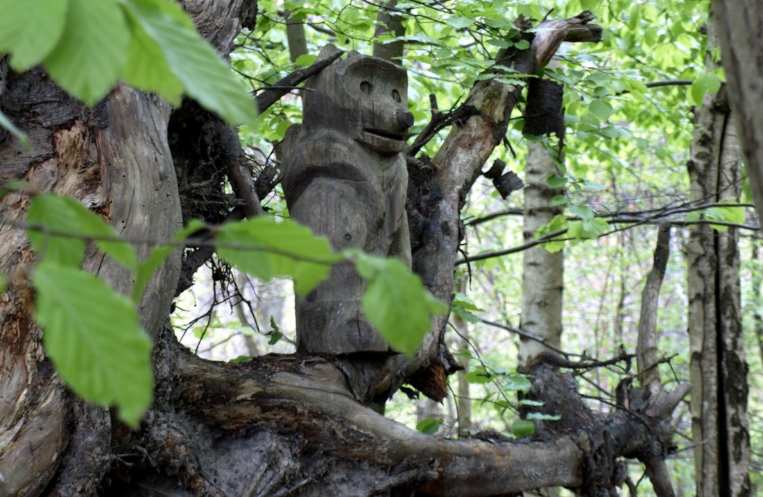 aus Holz geschnitzter Affe sitzt in einem Baum