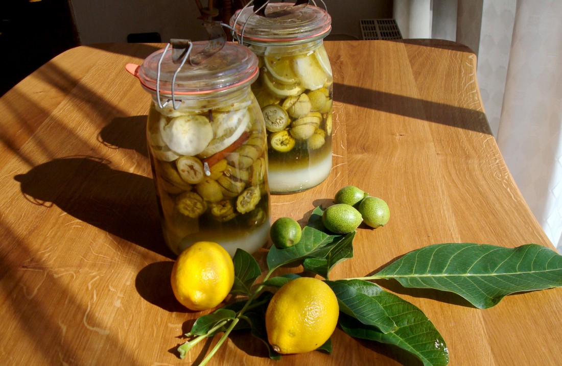 Nuts on a table, next to glasses with pickled berries